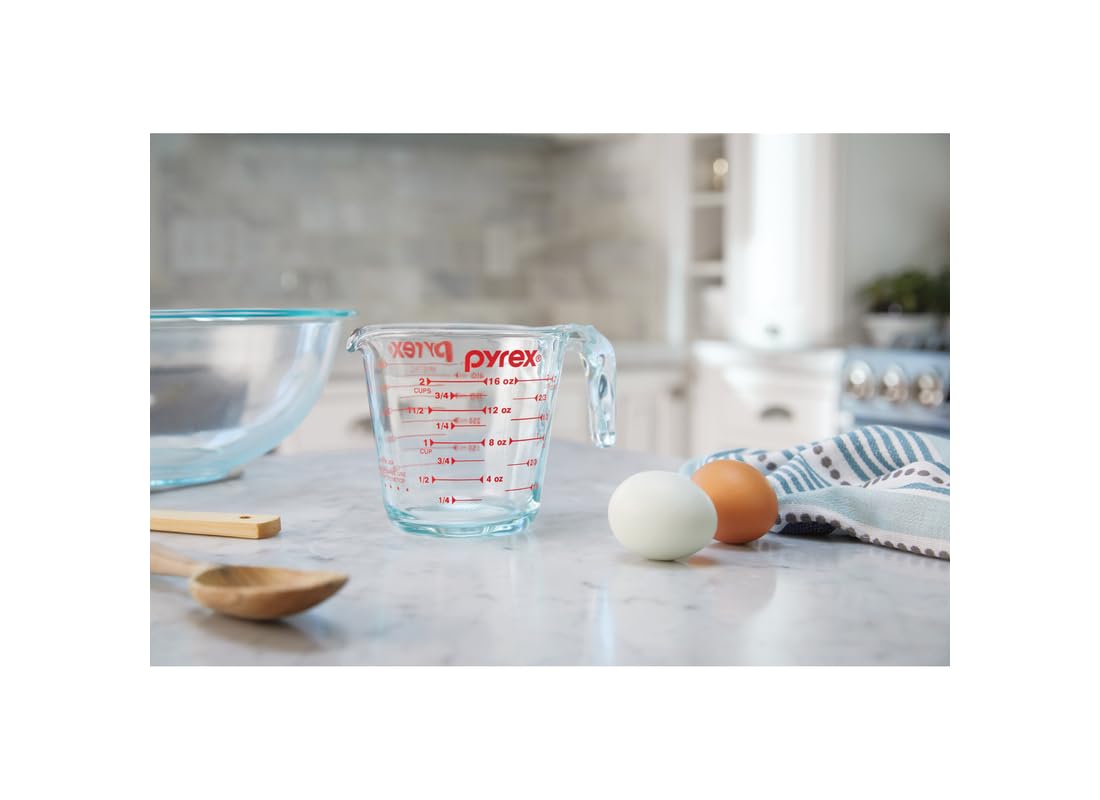 Pyrex measuring cup with red graphics, microwave safe for quick heating.