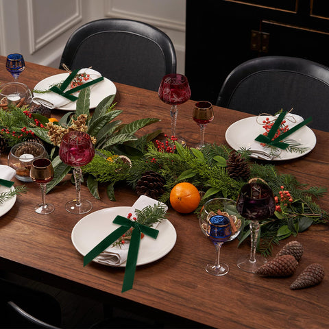 Riceshoot green velvet bow napkin ring beside wine bottle display