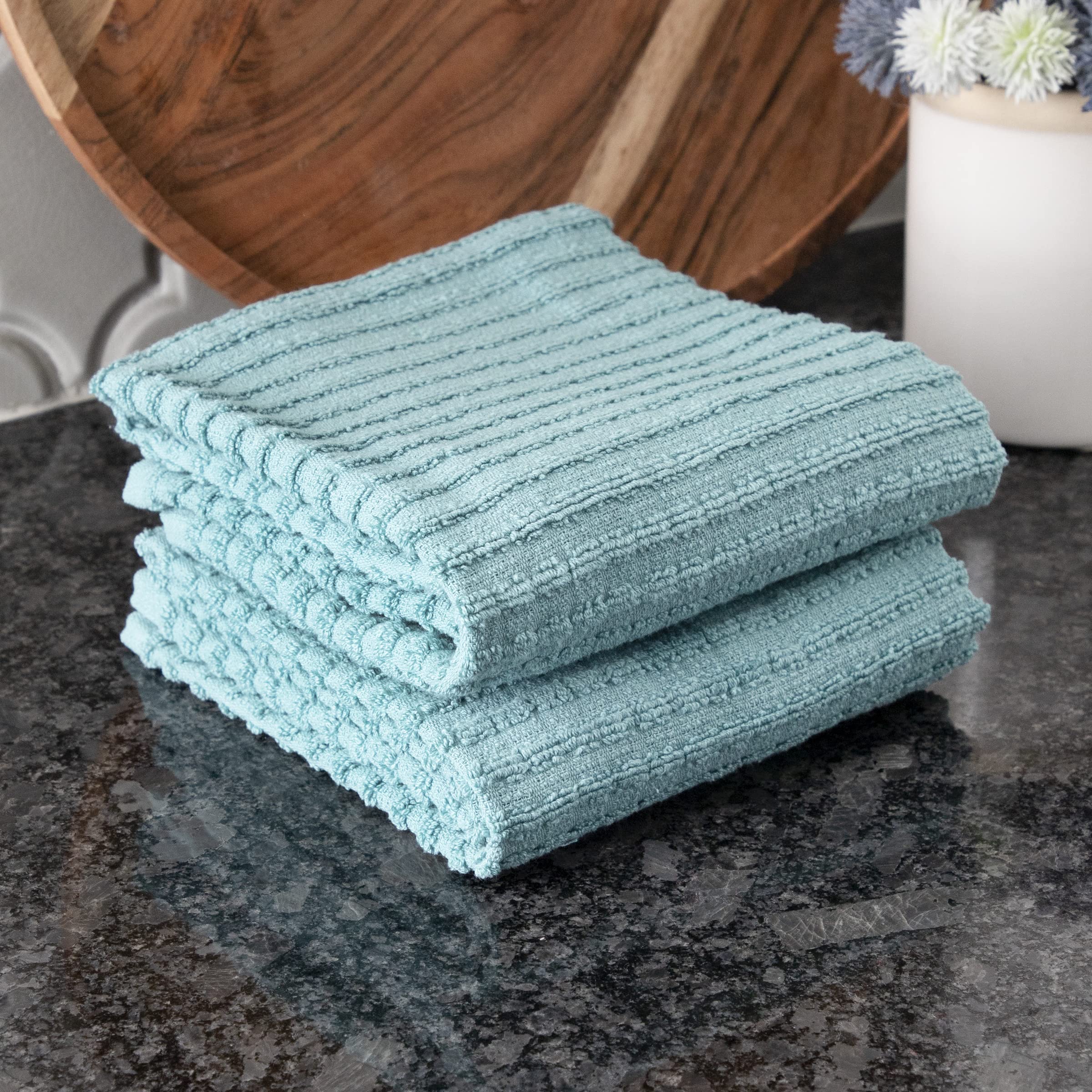Towel being used to wipe a spill, demonstrating absorbency.