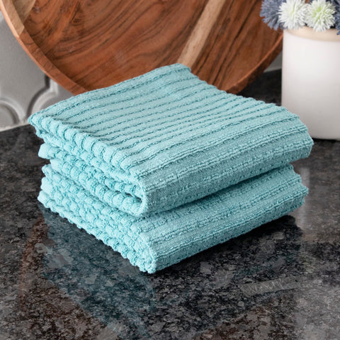 Towel being used to wipe a spill, demonstrating absorbency.