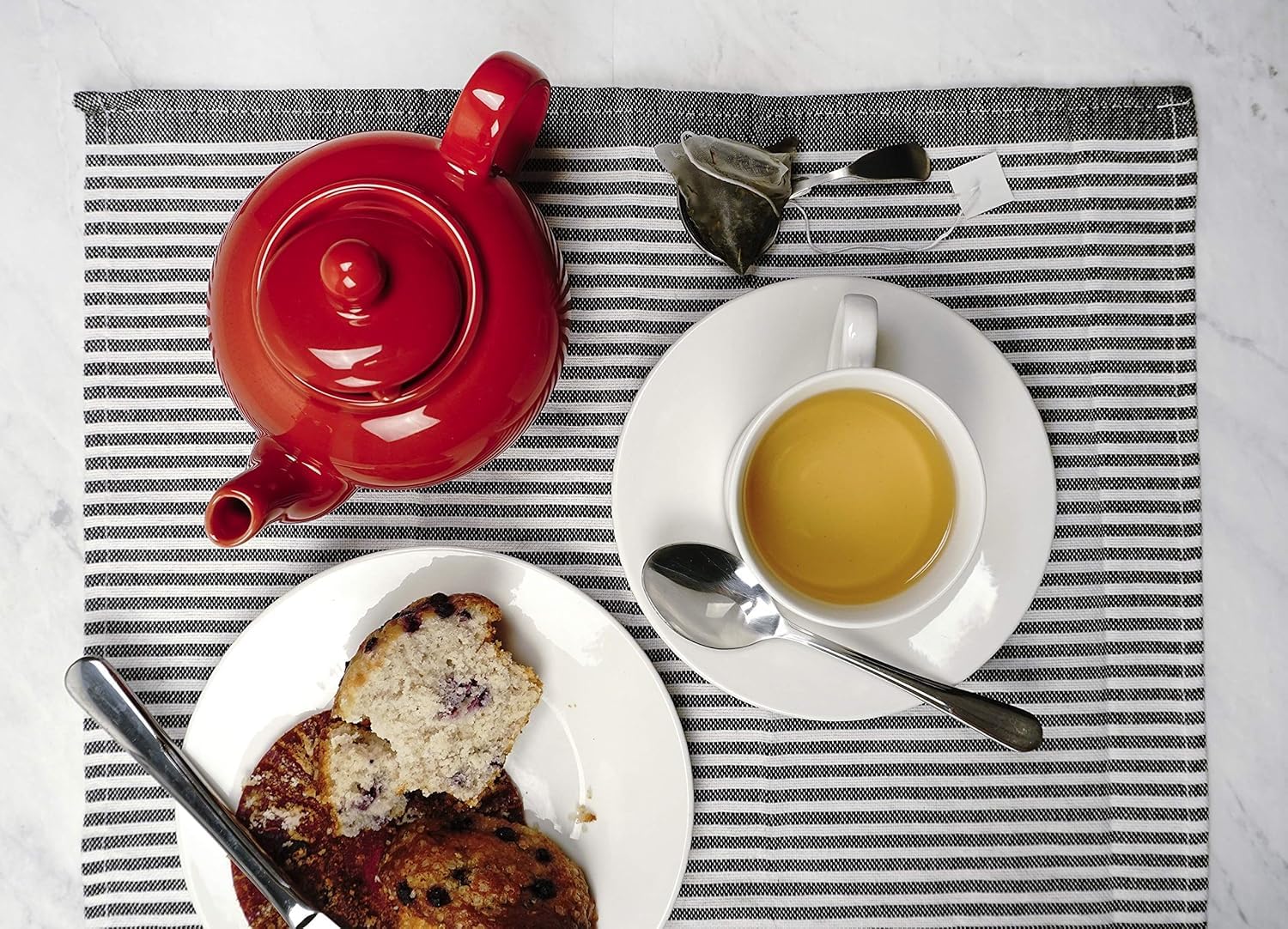RSVP International red teapot on a dining table for cozy gatherings.