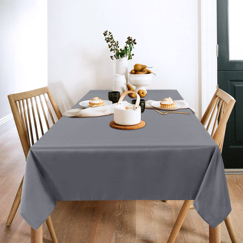 Sancua light grey tablecloth 60x102 on a dining table with settings, creating an elegant backdrop.