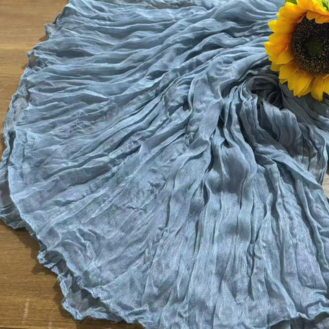 Seveups dusty blue cheesecloth table runner soft fabric texture under lighting.