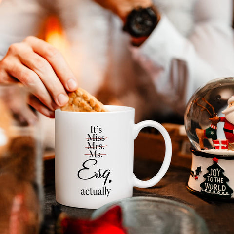 Shqiueos women lawyer mug on table scene, celebrates milestones.