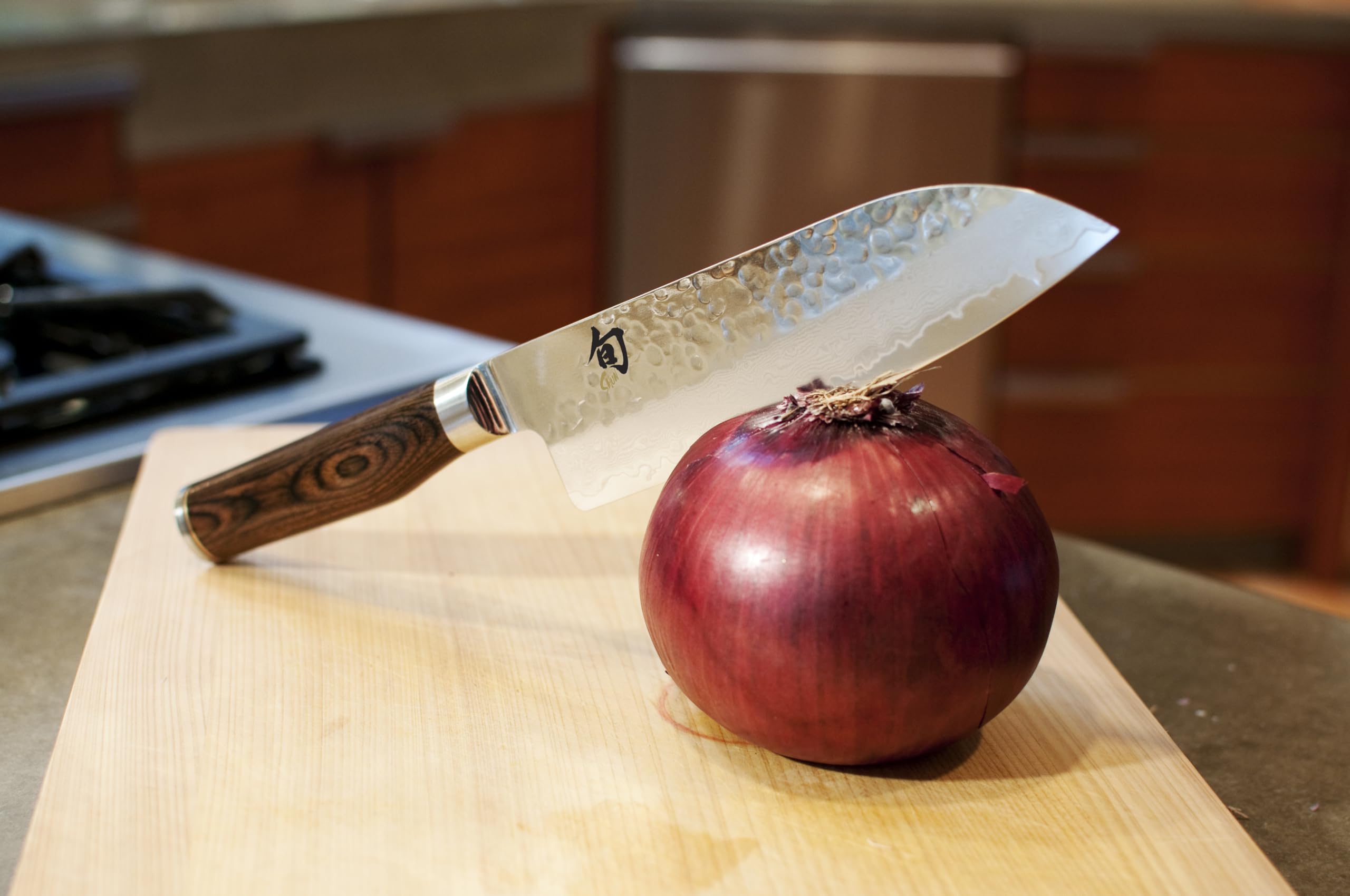 Shun Premier Santoku with hammered Tsuchime finish promotes easy food release.