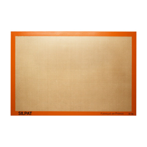 Silpat original non-stick baking mat full size on a sheet pan for easy cleanup.