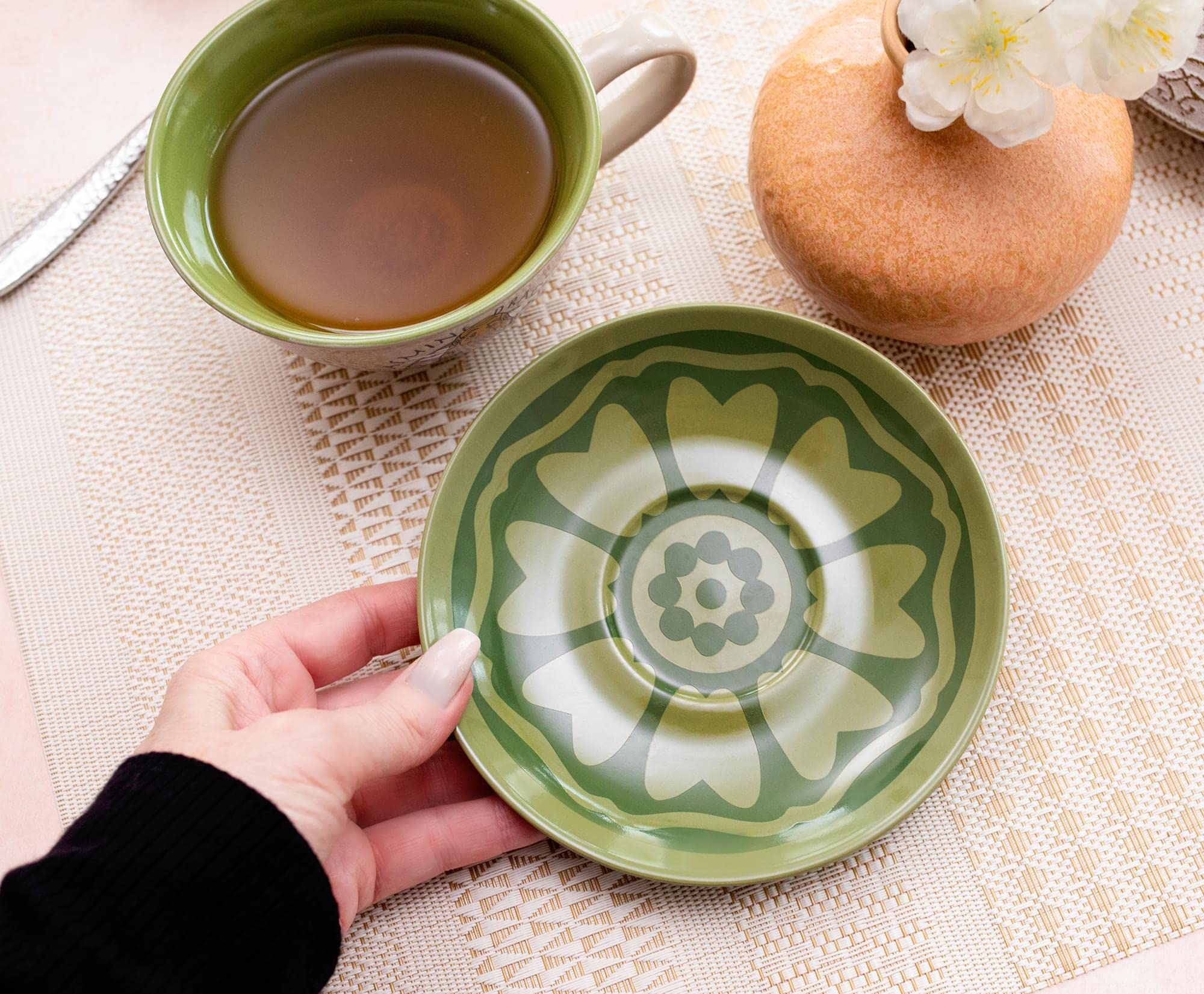 Silver Buffalo teacup with green interior enhances tea service.