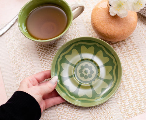 Silver Buffalo teacup with green interior enhances tea service.