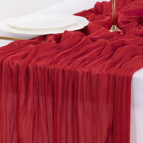 Socomi red cheesecloth table runner as elegant event backdrop.