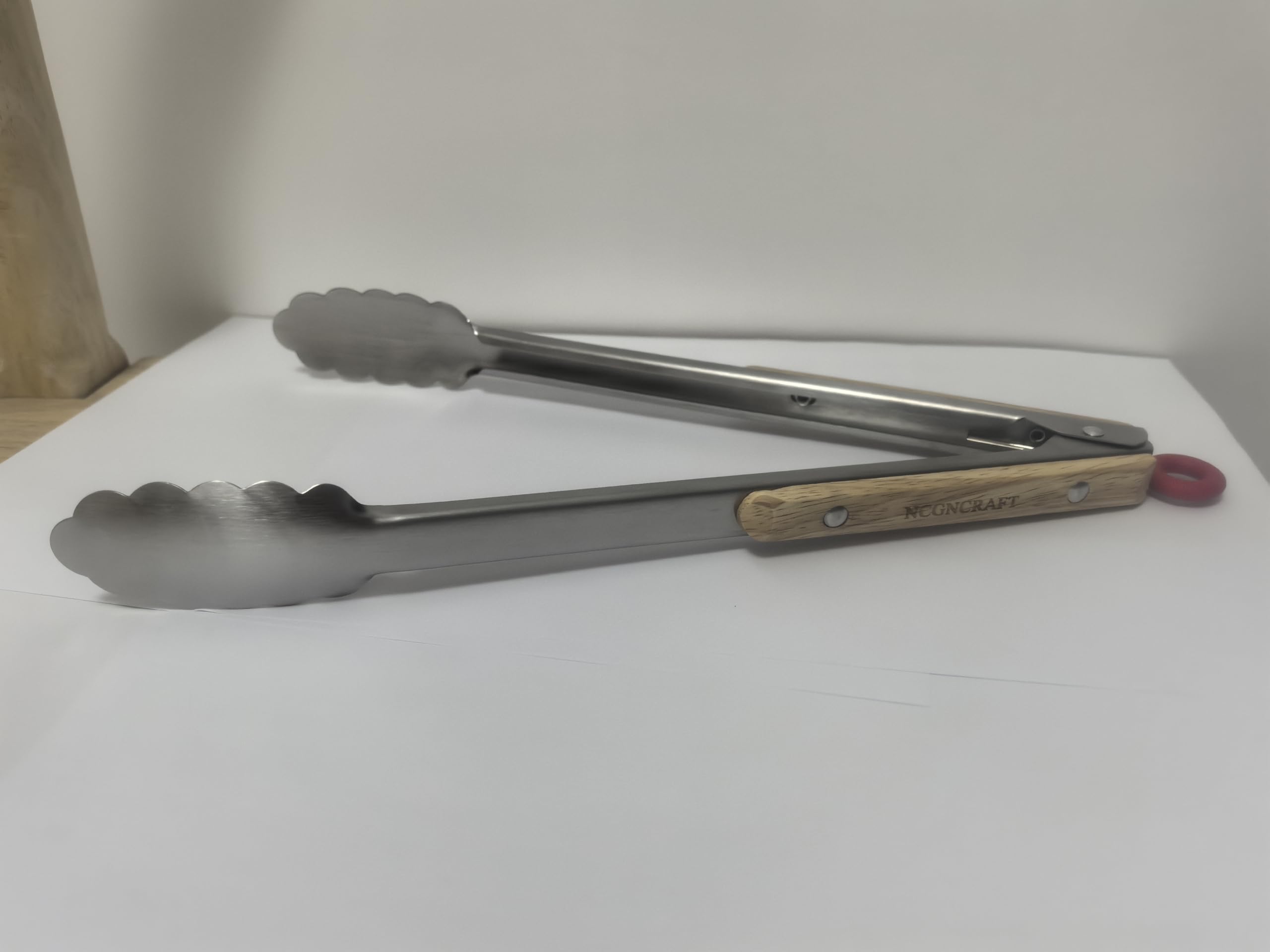 Stainless steel kitchen tongs heavy-duty construction seen during frying.