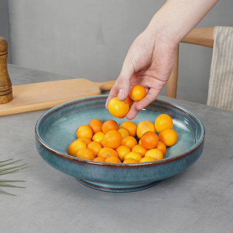 STE-CER blue fruit bowl on pedestal base elevates fruit and decor.