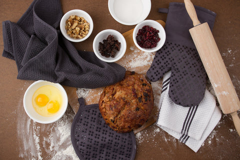 Sticky Toffee gray towels in use, wiping a spill with quick, absorbent performance.