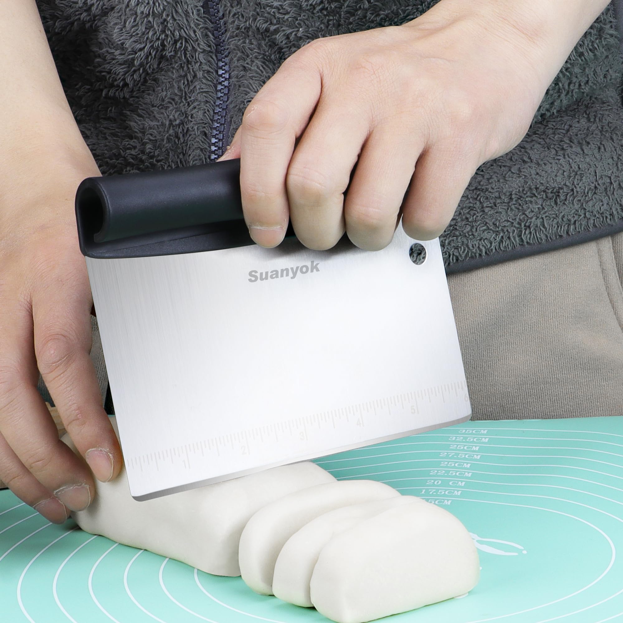 Suanyok flexible plastic dough scraper edge for shaping dough on a silicone mat.