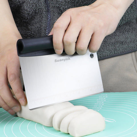 Suanyok flexible plastic dough scraper edge for shaping dough on a silicone mat.