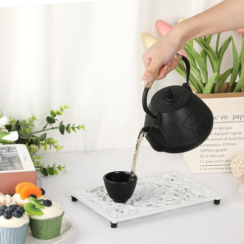 Sumnacon teapot mat use with white trivet on table.