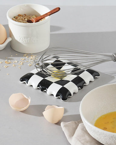Swicken checkered spoon rest at coffee station, keeps utensils tidy.
