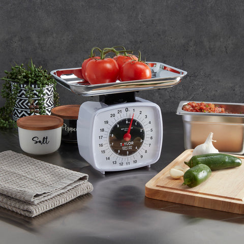 Taylor analog kitchen scale on a kitchen counter for everyday weighing.