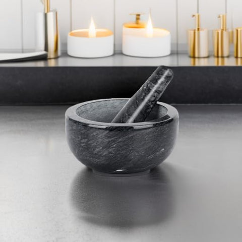 Tera marble set crushing garlic and herbs by hand.