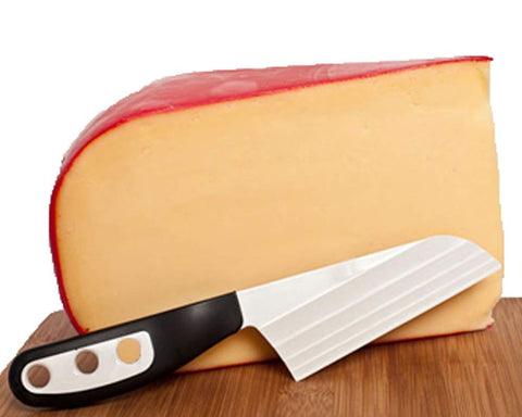 The Cheese Knife BKP2 on a cheese board showing clean slicing with minimal cheese on the blade.