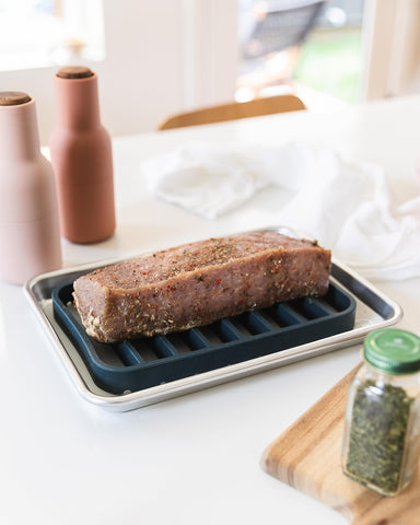 Dishwasher-safe navy silicone roasting rack eases cleanup after roasting vegetables and proteins.