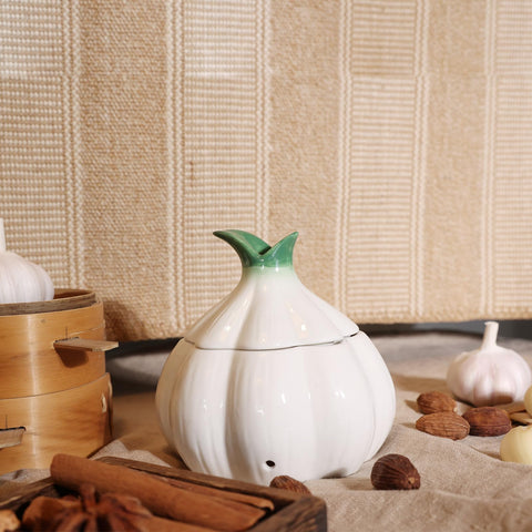 TOIVO Ceramic garlic keeper in white finish resting on a kitchen surface.