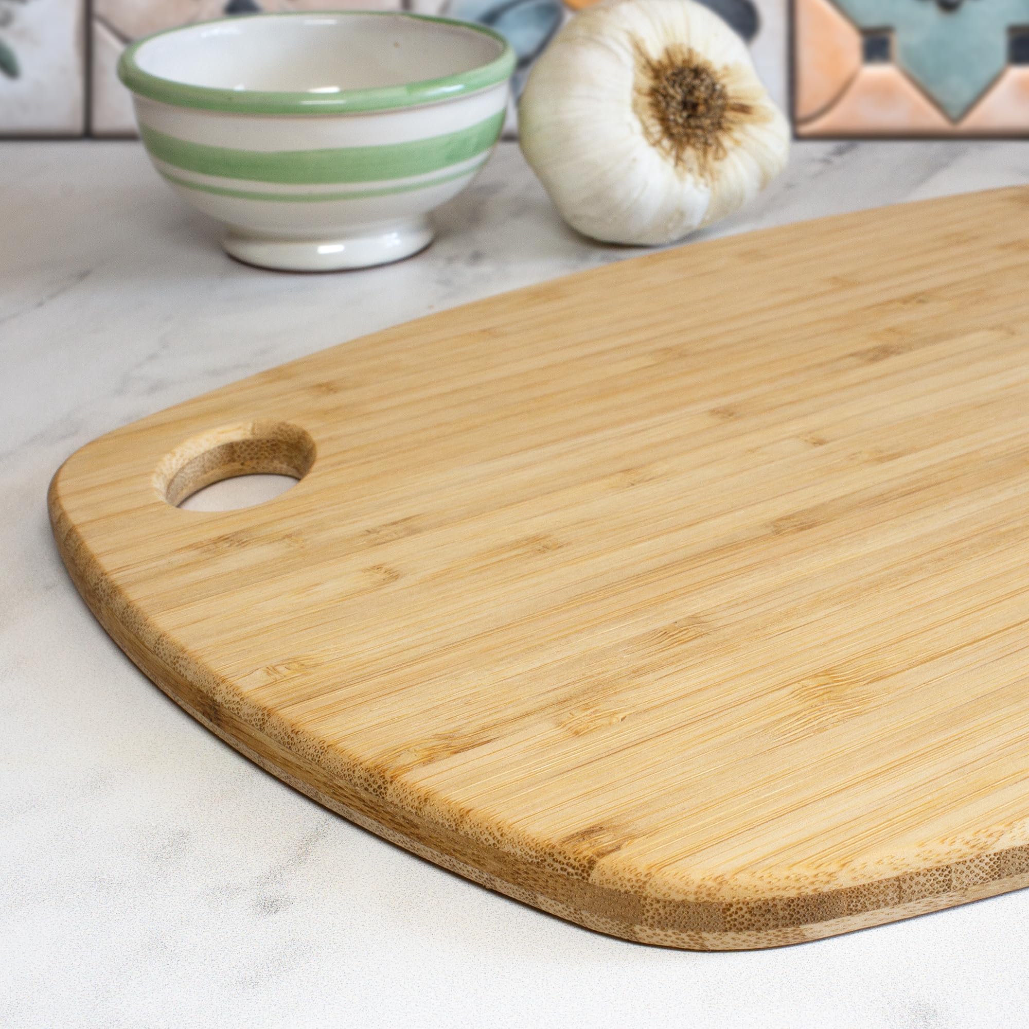 Totally Bamboo Greelite knife-friendly bamboo board protects blades during slicing.