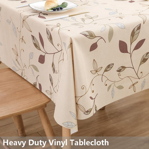 TruDelve beige vinyl tablecloth drapes over a table for elegant dining.