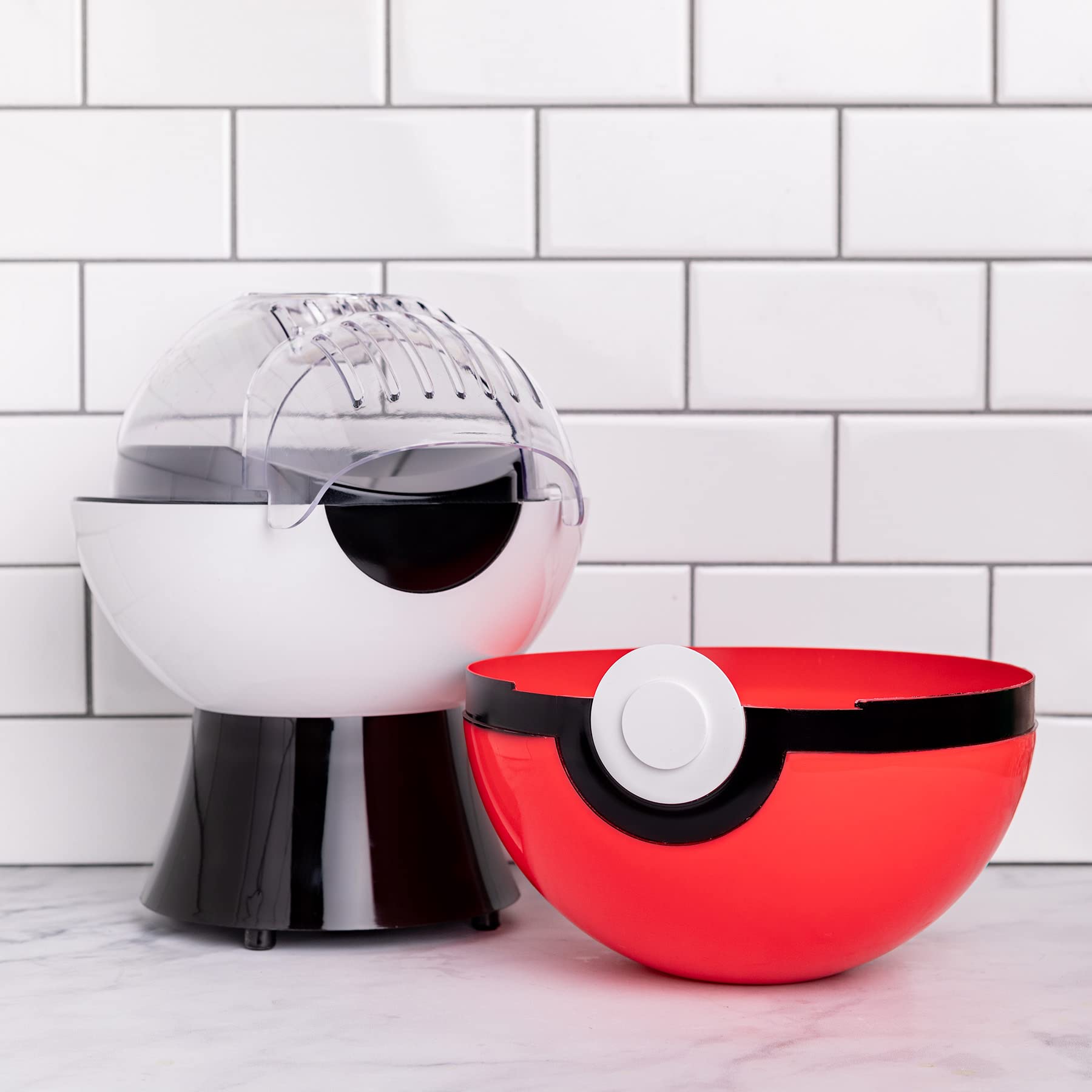 Uncanny Brands Poké Ball popcorn maker vibrant Poké Ball design.