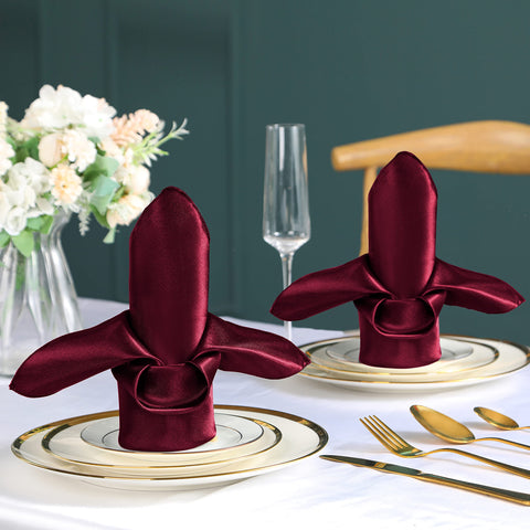 VACVELT Burgundy satin napkins on a table setting adding luxurious shimmer.