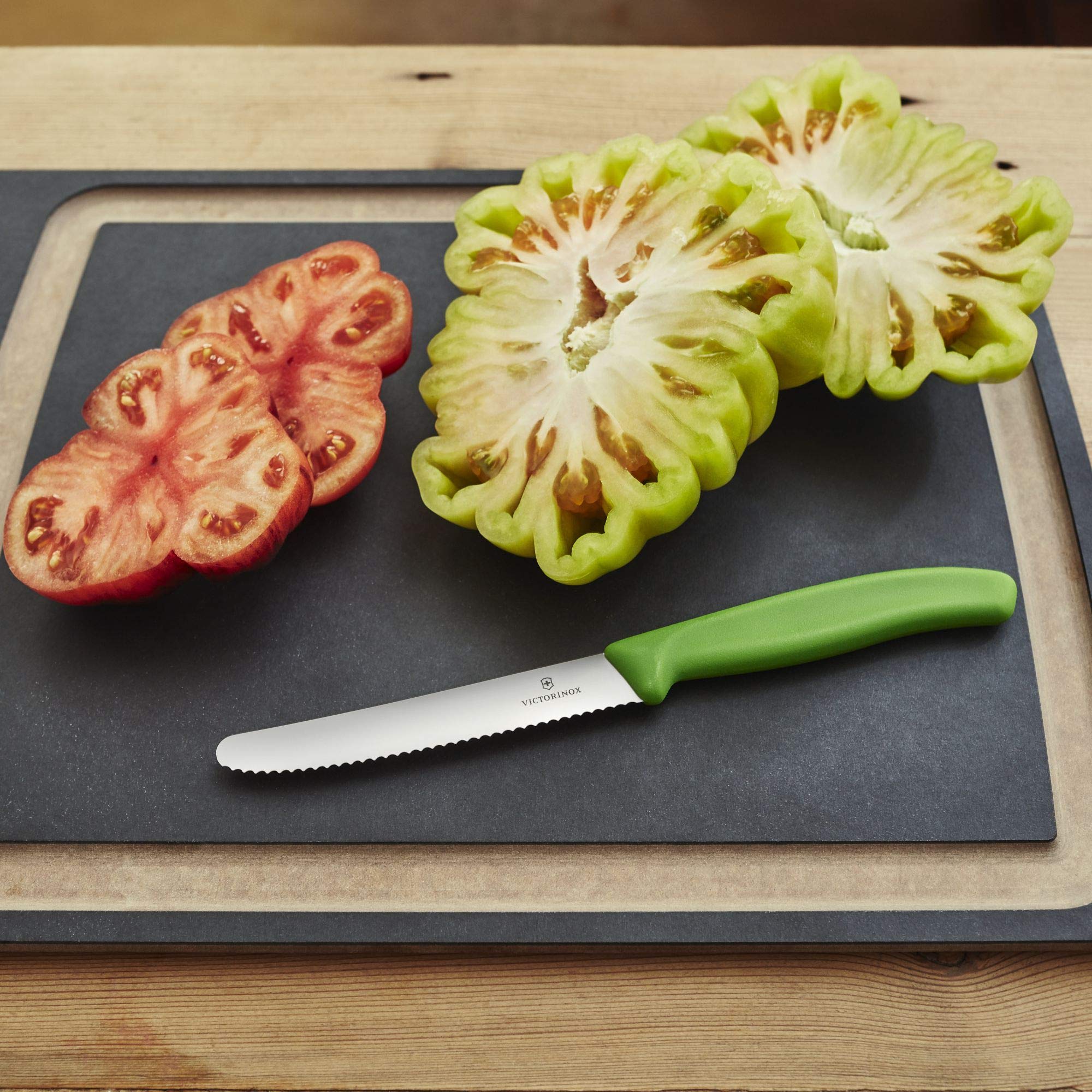Victorinox Swiss Classic tomato knife green handle full view on a dish for everyday prep