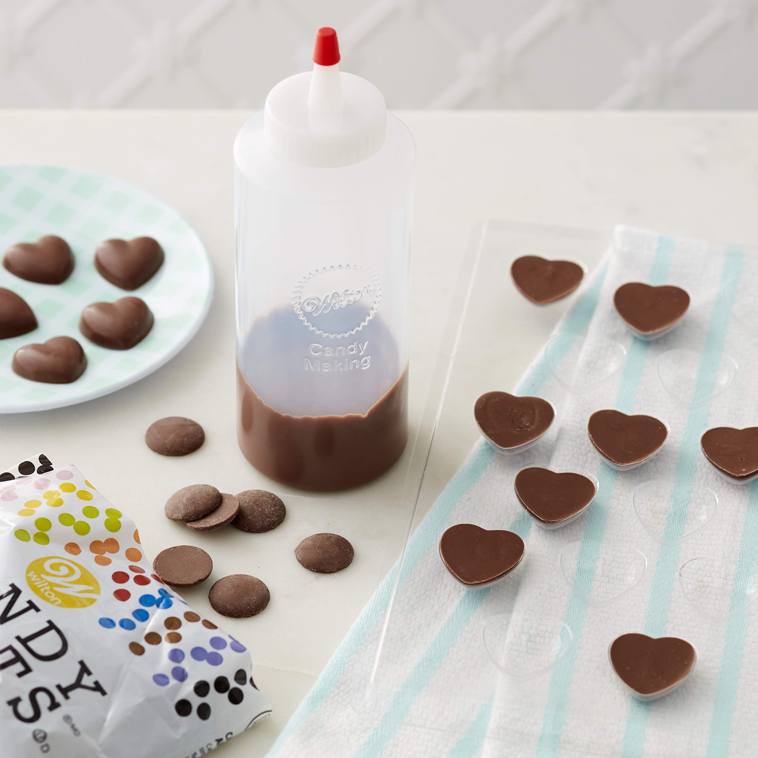 Wilton candy melts squeeze bottle in action, enables mess-free candy creation and easy reheating.