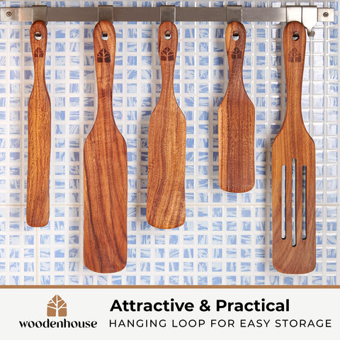 Teak spurtle scrapes the bottom of a jar with thorough contact.