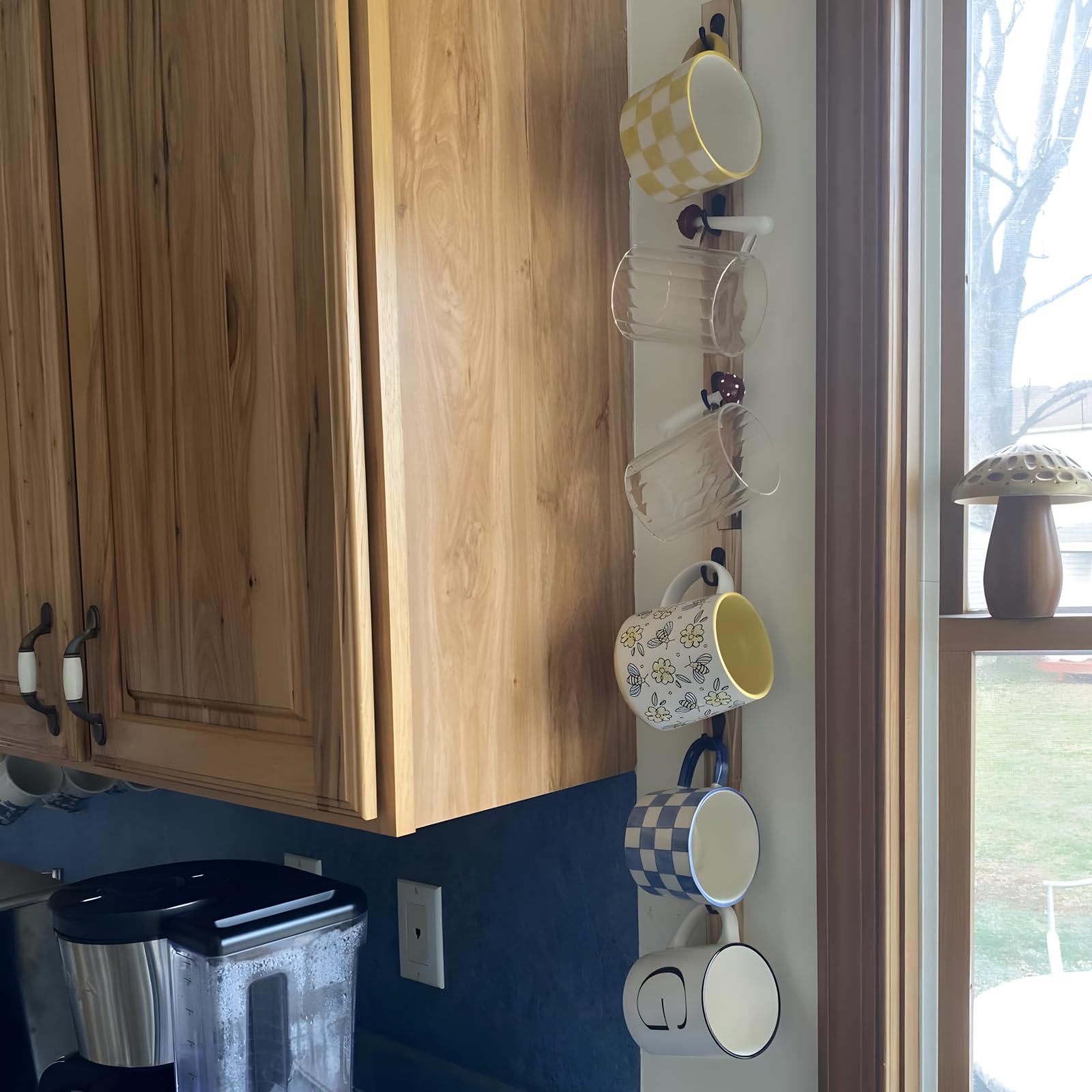 Space saving kitchen mug organizer mounted on wall for decluttered countertop