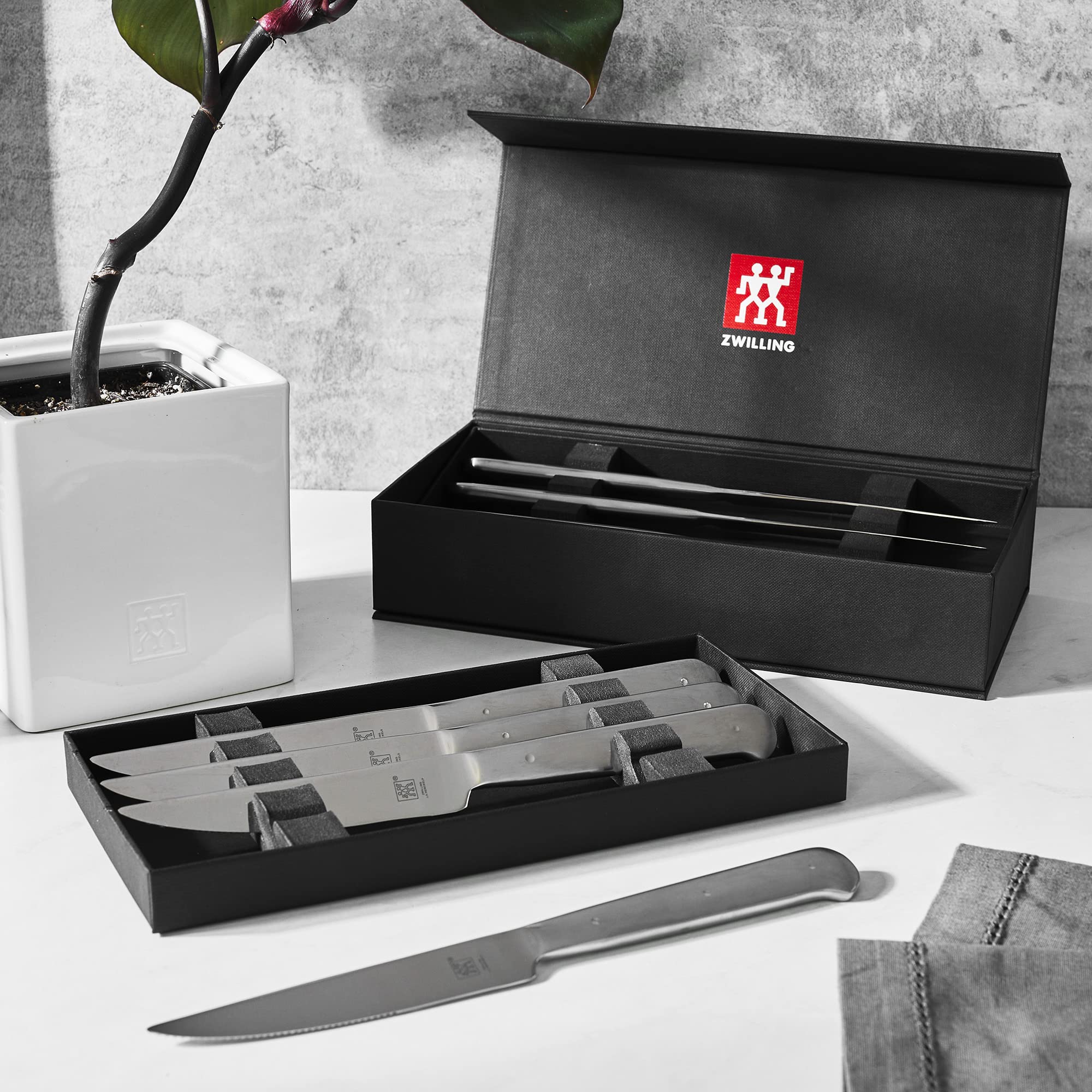 ZWILLING eight-piece steak knife set neatly arranged for dinner service.