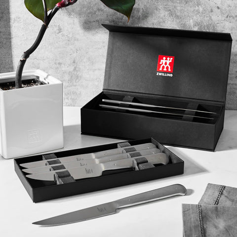 ZWILLING eight-piece steak knife set neatly arranged for dinner service.